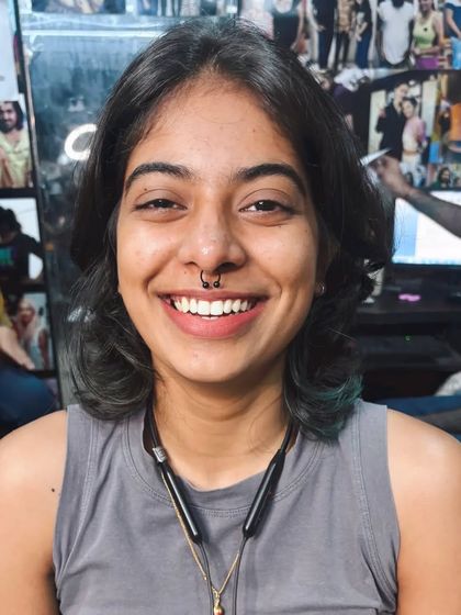 A smiling client showing off her new septum ring. Seeing my clients happy with their new body art is the best part of my job.