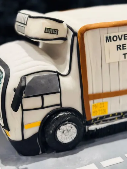 A side view of the refrigerated truck cake, highlighting the detailed paneling and custom text. I use fondant and edible paints to achieve a clean, realistic finish on vehicle cakes.