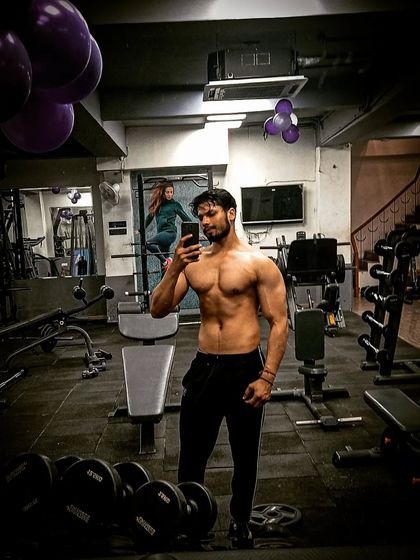 A shirtless mirror selfie showing ab definition and overall conditioning.