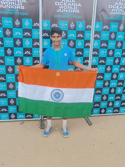 Tavish proudly holding the Indian flag after the team's victory at the ITF World Juniors Team Competition. Representing the nation is a powerful motivator for my athletes.