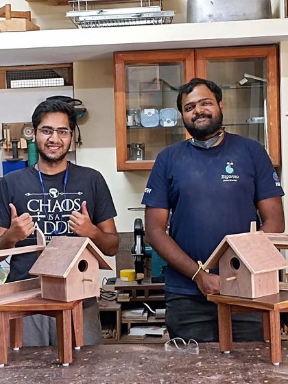 The friends, Tejus and Nihal, with their completed projects. They each built a stool, a shelf, and a birdhouse, experiencing both hand tools and power tools over the weekend.