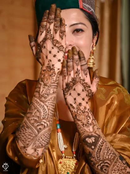A playful 'peek-a-boo' shot with the bride hiding behind her beautifully decorated hands.