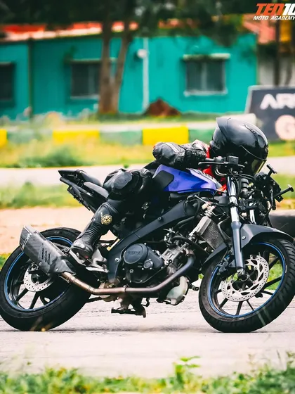 A rider in a full tuck position, leaning into a turn on a modified training bike. We work on getting you comfortable with the aggressive ergonomics of a sportbike in a controlled environment.