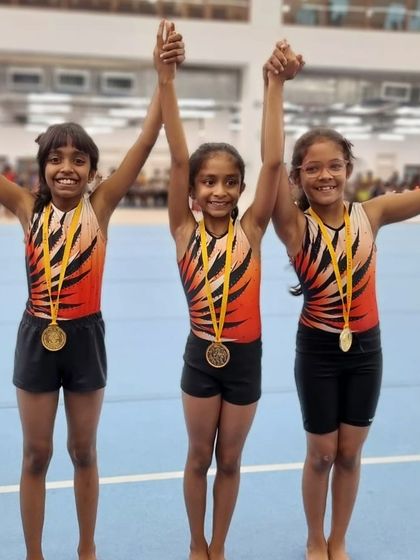 Victory is sweetest when shared. Three of my students celebrate together after winning their medals, holding hands high to acknowledge their collective success.