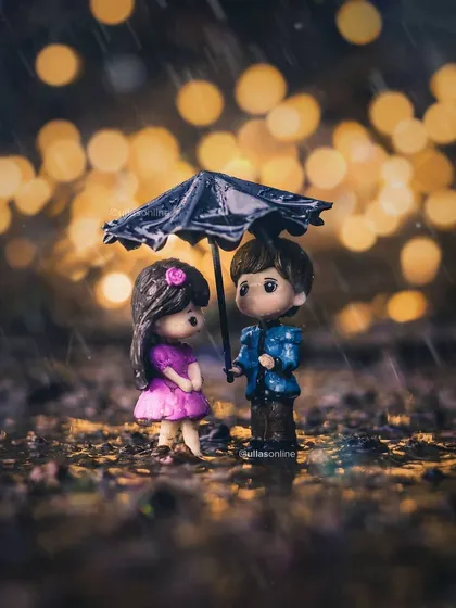 A charming miniature scene of a couple sharing an umbrella in the rain, with beautiful bokeh lights in the background. This creative still life photo shows how imagination can create a magical world in a small space.