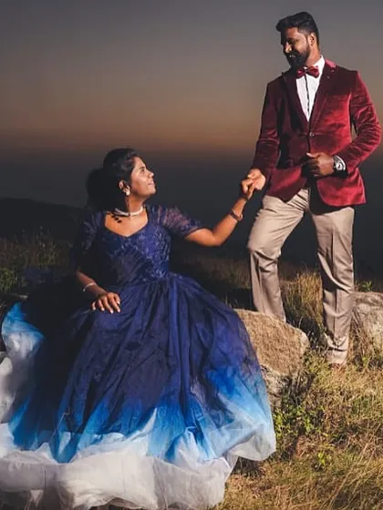 We help you find the perfect matching outfits for any location. This couple chose a beautiful blue gown and a stylish red velvet blazer for their pre-wedding shoot, creating a stunning contrast against the hillside backdrop.