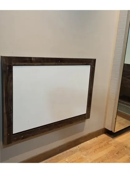 This is the wall-mounted study table in its folded position. It sits flush against the wall with a clean wooden frame, ensuring it doesn't get in the way.