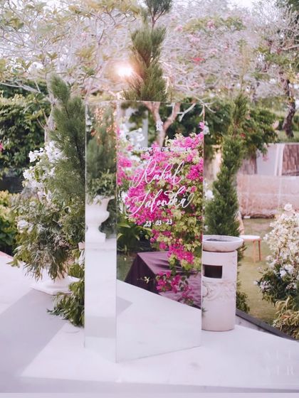 A mirrored welcome sign at our Bali wedding, reflecting the lush bougainvillea of the resort. This was a simple yet elegant way to greet guests.