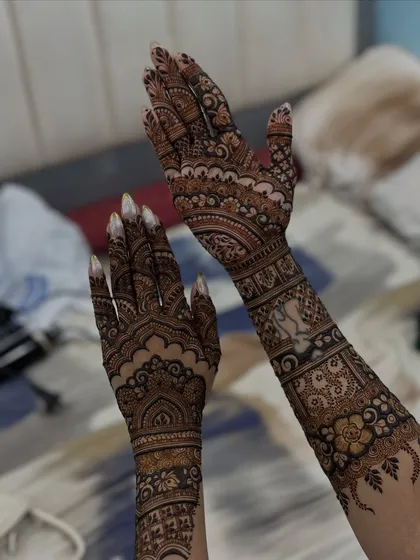The bride raising her hands to show the full extent of her gorgeous floral mehendi.