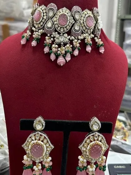 A close-up of the pink choker set from my customizable collection. This rental piece features pink stones with green enamel details.