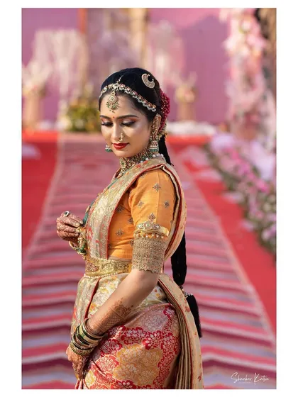 Another view of the bride in her Paithani saree, highlighting the intricate details of her custom orange blouse and traditional jewelry.