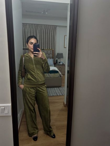 A mirror selfie in a comfortable olive green velour tracksuit. Perfect for travel days or lounging at home in style.