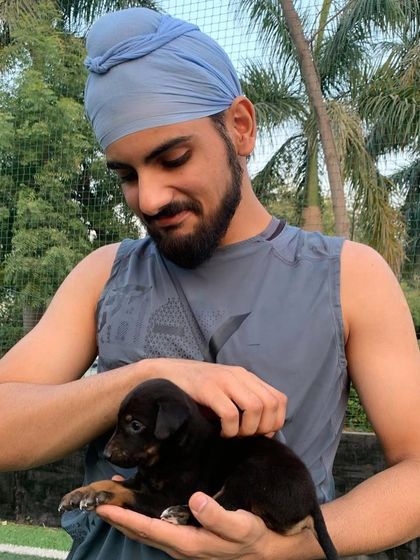 A participant gently holds a tiny black puppy in his hands, sharing a quiet moment of connection.