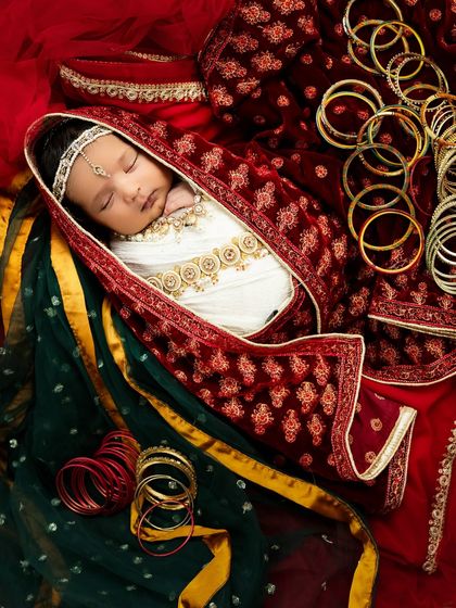 This creative setup for a baby Radha includes traditional bangles and a colorful dupatta, adding cultural richness and beautiful details to the portrait.