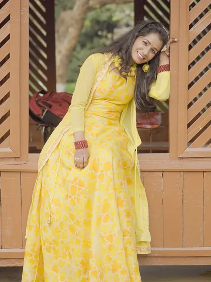 A relaxed pose during an outdoor shoot. The model is wearing a yellow Anarkali-style dress, showing how I capture both posed and in-between moments.