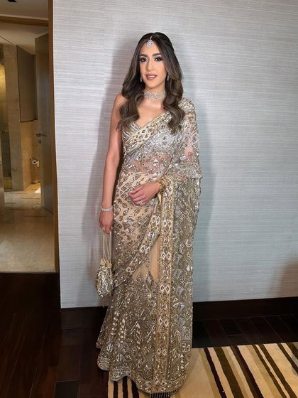 Another full-length shot showing the beautiful fall of the saree and the elegant posture of the client.