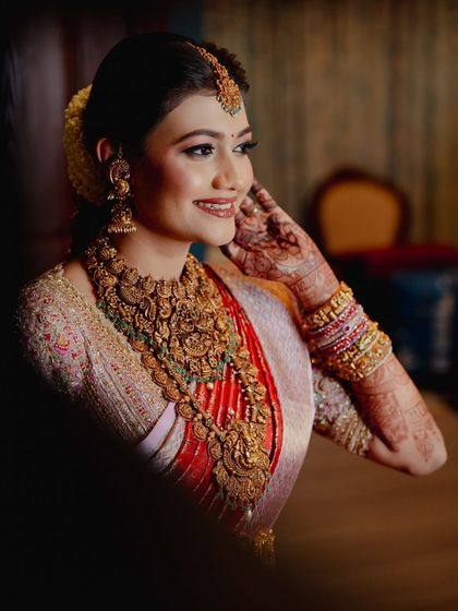 A candid moment capturing the bride's beautiful smile and her gracefully adorned hands.