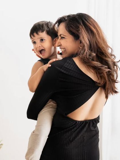 A candid shot of a mother holding her laughing son, capturing a moment of pure, unscripted joy.