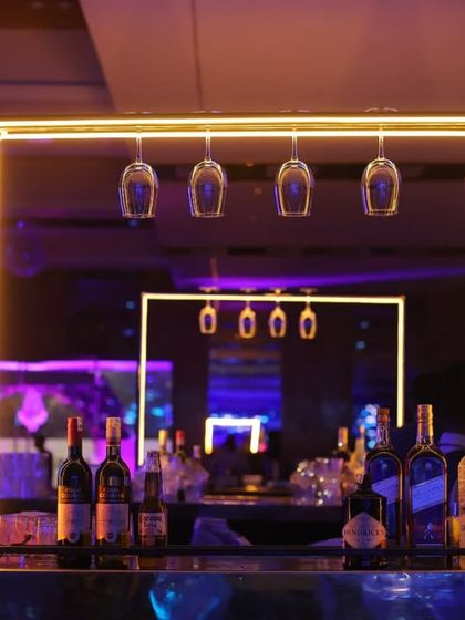The stylish bar setup at the Diwali party. The neon lights and hanging glasses create a modern and sophisticated look that I love to capture.