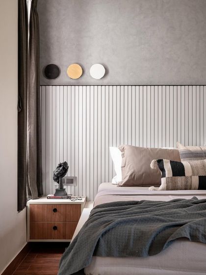 Another view of the master bedroom with the rafter headboard. The three-disc art piece above the bed adds a simple, graphic element to the textured grey wall.