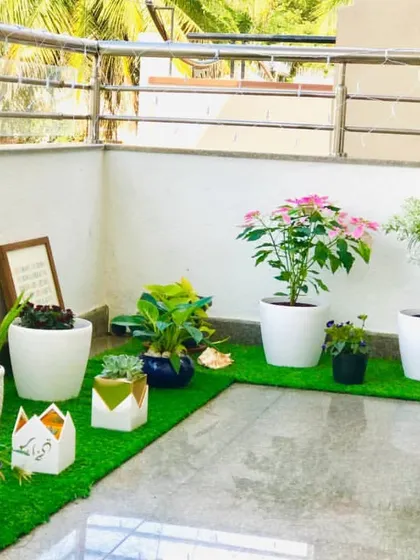 This is a simple yet beautiful balcony transformation for a client in Sanjay Nagar. A patch of artificial grass and a curated collection of potted plants is all it took to create a charming green corner.