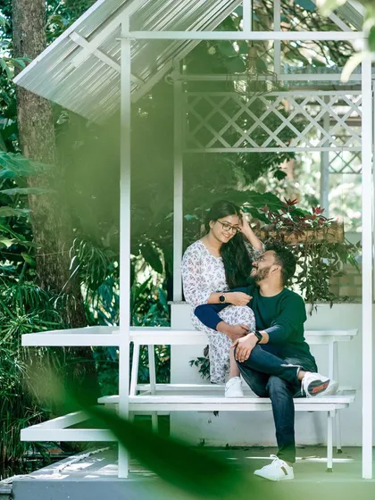 A quiet, romantic moment shared in a white garden gazebo. The surrounding greenery and soft light make this a perfect spot for an intimate and serene pre-wedding photograph.