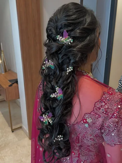 A dreamy and whimsical braid adorned with butterfly and pearl hair accessories. This is a perfect hairstyle for a sangeet or mehendi.