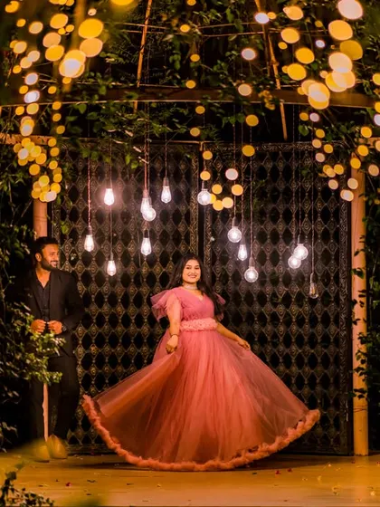 As night falls, we use the magic of light to create a truly romantic atmosphere. This shot, framed by a canopy of warm lights, shows how we can craft an intimate, dreamy portrait that feels like a scene from a movie.