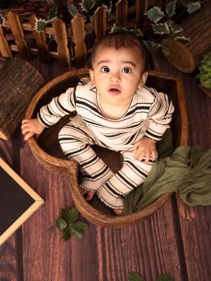 A unique, top-down view of this little one nestled in a heart-shaped wooden bowl, part of our "Wild One" jungle theme.