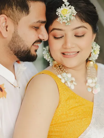 A sweet moment from Samridhi's Haldi. Her makeup was kept very natural and dewy, complemented by beautiful floral jewelry for that perfect, fresh Haldi look.
