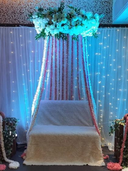 Another version of the floral canopy decor, this time using all-white flowers for a more subtle and elegant look. The fairy light backdrop adds a warm glow to the setting.