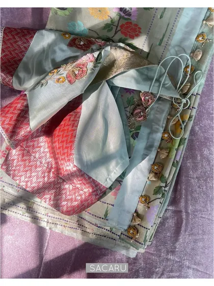 A flat lay of the fabrics and embellishments used for the custom Paithani saree blouse, showcasing the beautiful color palette.