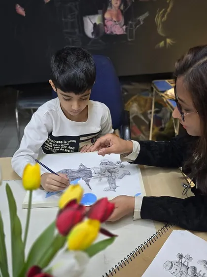 An instructor provides one-on-one guidance to a young student. We ensure every artist gets personal attention to help them with their specific needs.