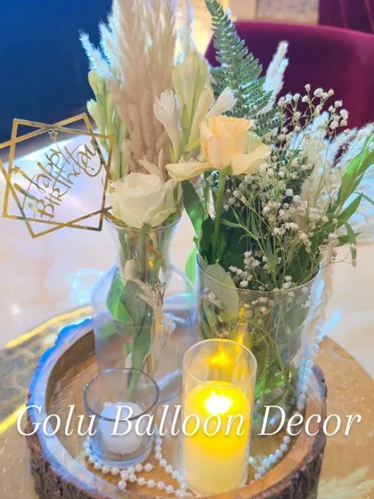 A lovely boho-style table centerpiece with fresh flowers, pampas grass, and candles, adding a touch of elegance to the celebration.