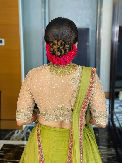 This is a beautiful example of a classic bridal bun, perfect for a reception. I created an intricate braided bun and surrounded it with vibrant fresh flowers, a look that is both traditional and stunningly beautiful.