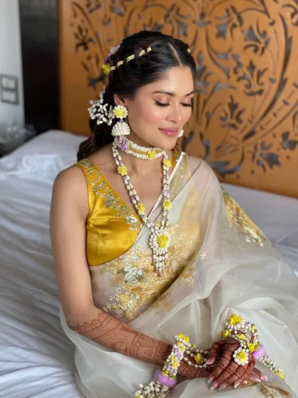 My bride Kashish looking like a breath of fresh air for her Haldi, wearing a beautiful white and yellow saree with floral jewelry.