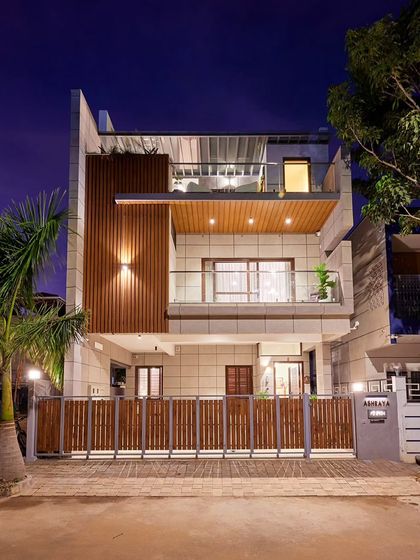 Another perspective of the Odion Woods villa at dusk, highlighting the warm interior light against the twilight sky.