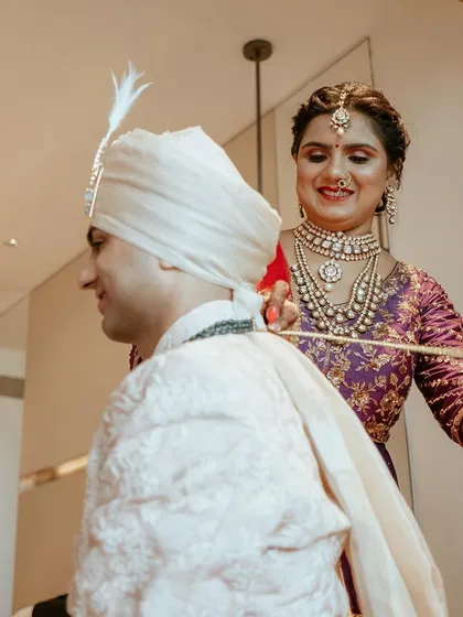 The groom's sister helps him with his safa, a lovely tradition that showcases the strong bond between siblings.