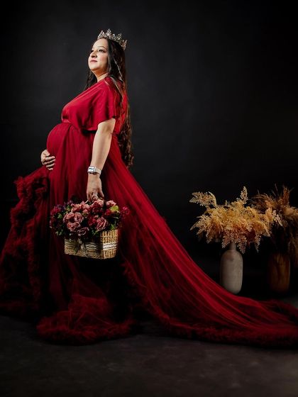 A stunning portrait of the mother-to-be, showcasing her radiant glow and the beautiful red gown. The makeup is glamorous yet feels light and comfortable.