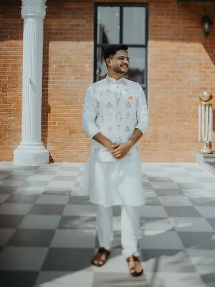 A full-length portrait of the groom, looking sharp and happy on his engagement day.