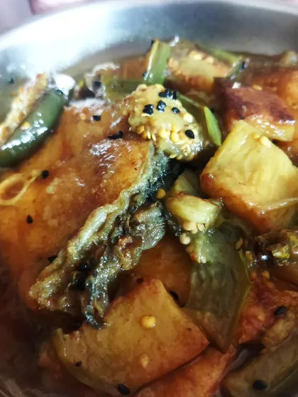 This is a simple yet incredibly tasty dish: Begun, Kancha Lonka aar Kaalo Jeerey diye Katla Maacher Jhol. It's a light fish curry with eggplant, green chilies, and nigella seeds that I often make when I want something quick but flavorful.