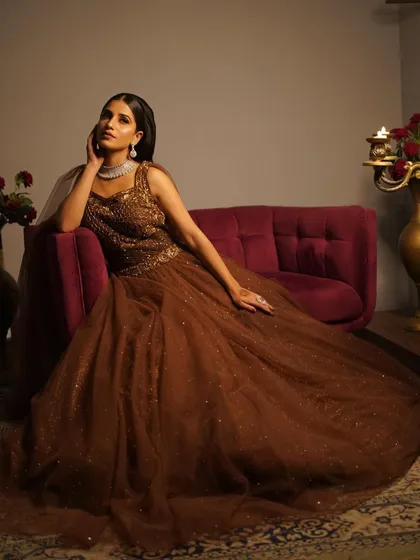 A poised and elegant portrait in a brown gown. The makeup is soft and neutral, letting the outfit and her natural beauty shine.
