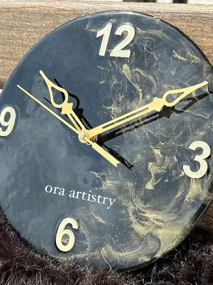 A mini black and gold marble resin clock. Even in a smaller size, the design is elegant and impactful.