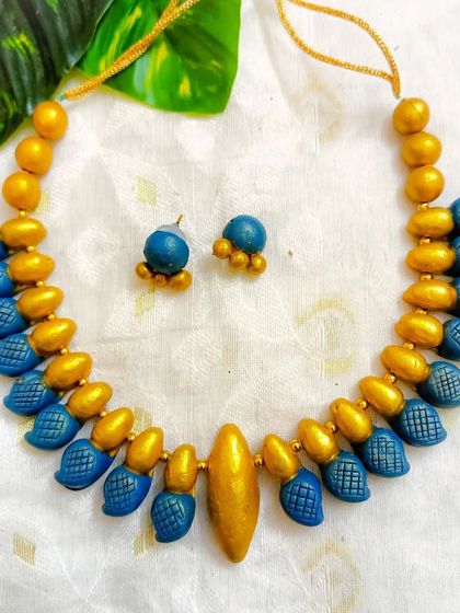A duplicate image of the blue and gold leaf-textured choker.