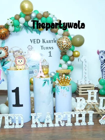 A jungle theme with lots of fun details, including animal print foil balloons and a light-up "ONE" sign. The themed pedestals add to the safari vibe.