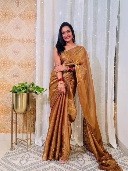 This golden organza saree is a perfect example of affordable luxury. It's a great choice for a wedding guest, giving a rich look without a heavy price tag.