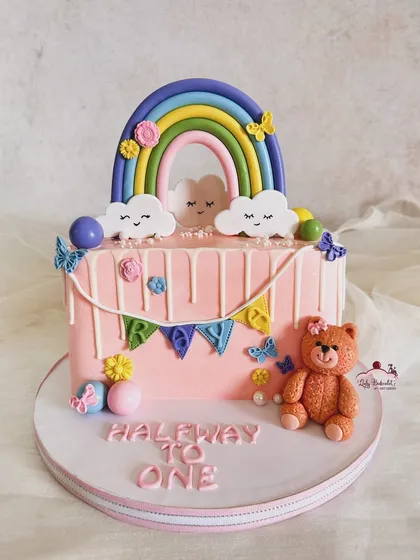 Another adorable half birthday cake, this one with a rainbow, teddy bear, and butterflies for baby Raya.