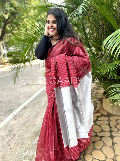 This maroon striped handloom cotton saree is a classic. The rich color paired with the simple stripes and silver pallu creates a look that is both sophisticated and easy to wear.