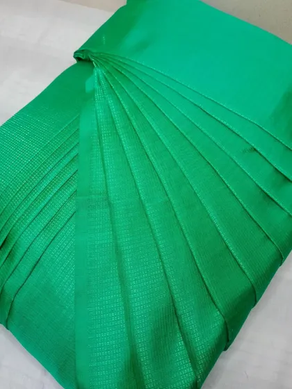A simple yet striking green saree, pleated and ready for box folding.