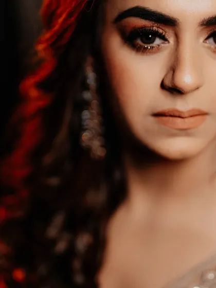A stunning close-up portrait of the bride. The dramatic lighting highlights her beautiful makeup and intense expression, creating a powerful and captivating image.